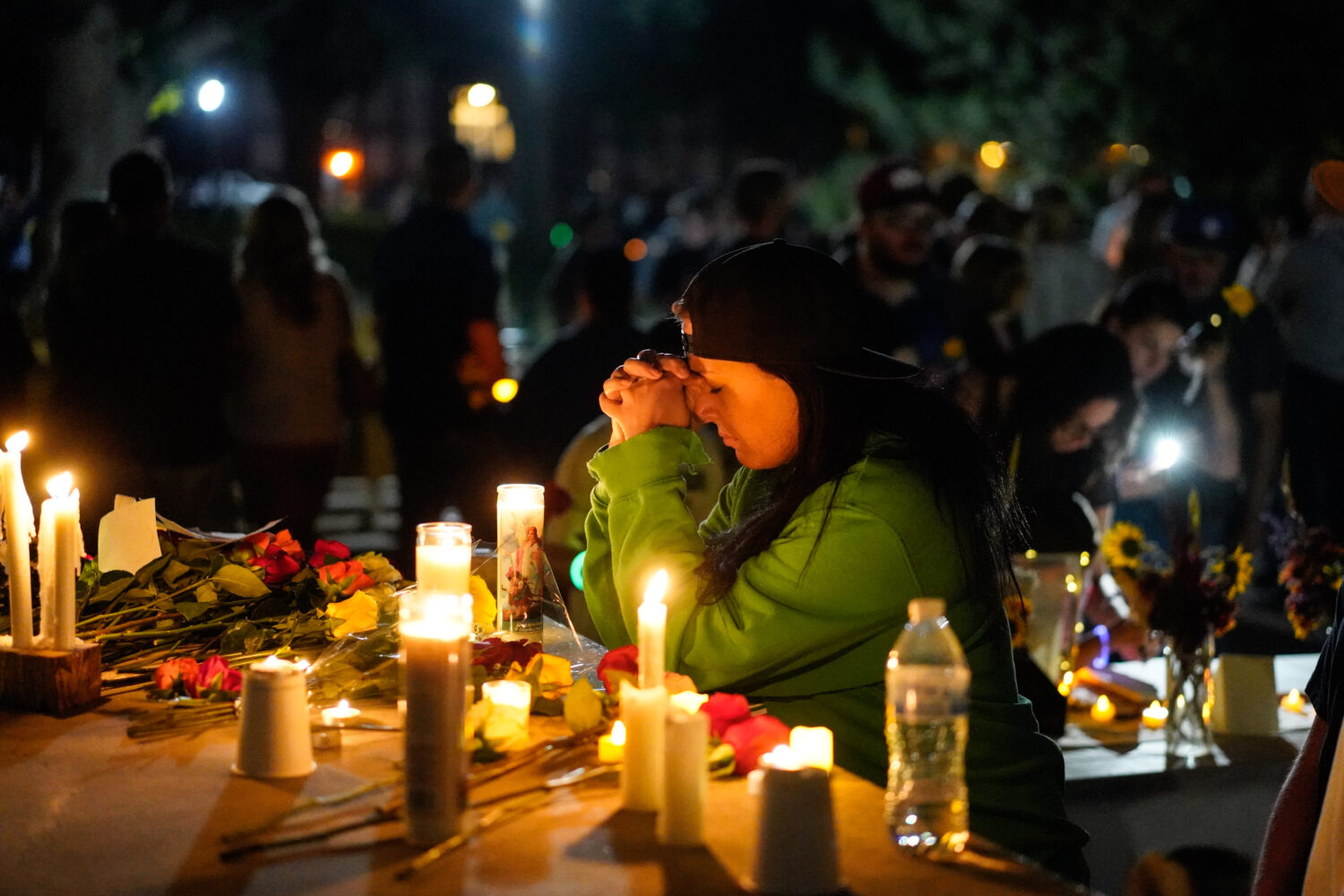 A woman prays during a candlelight vigil Tuesday, Aug. 4, 2026, in Twin Falls, Idaho, to honor the ...