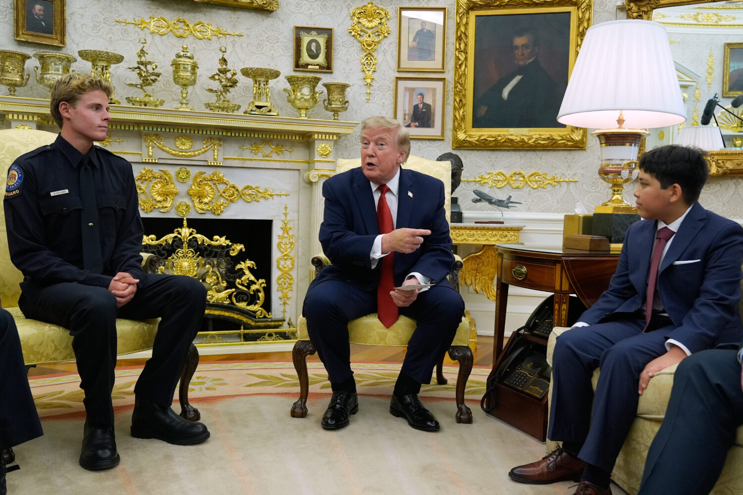 President Donald Trump gestures to Nathaniel Rai, the boy lifeguard Ryder Williams, left, saved as ...