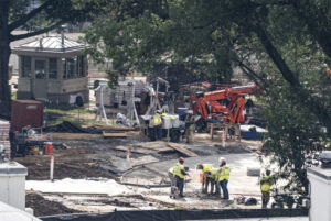 Crews remove the granite seal on the White House helipad, signaling potential project delays