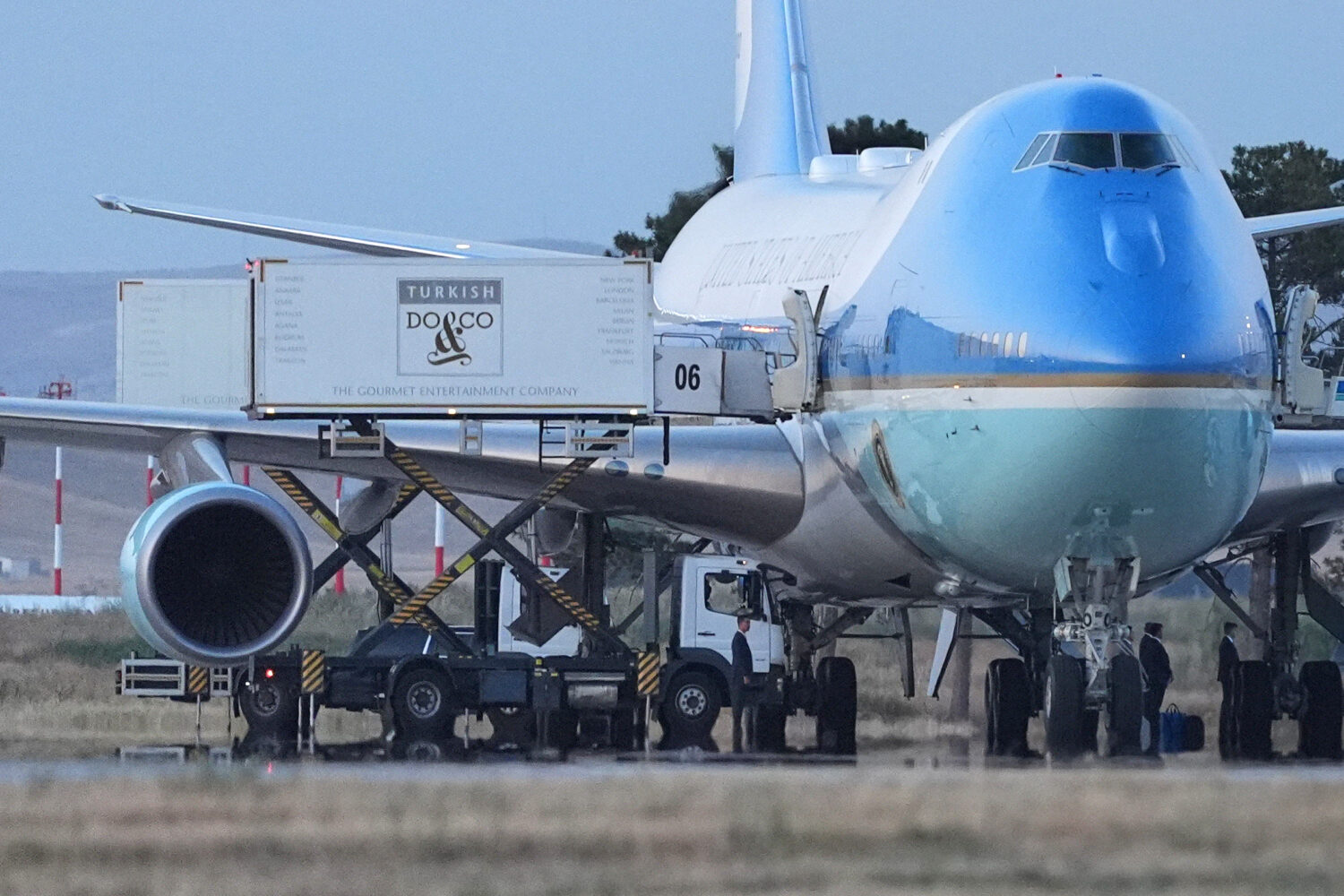 Catering trucks are parked at Air Force One on the tarmac as the motorcade carrying U.S. President ...