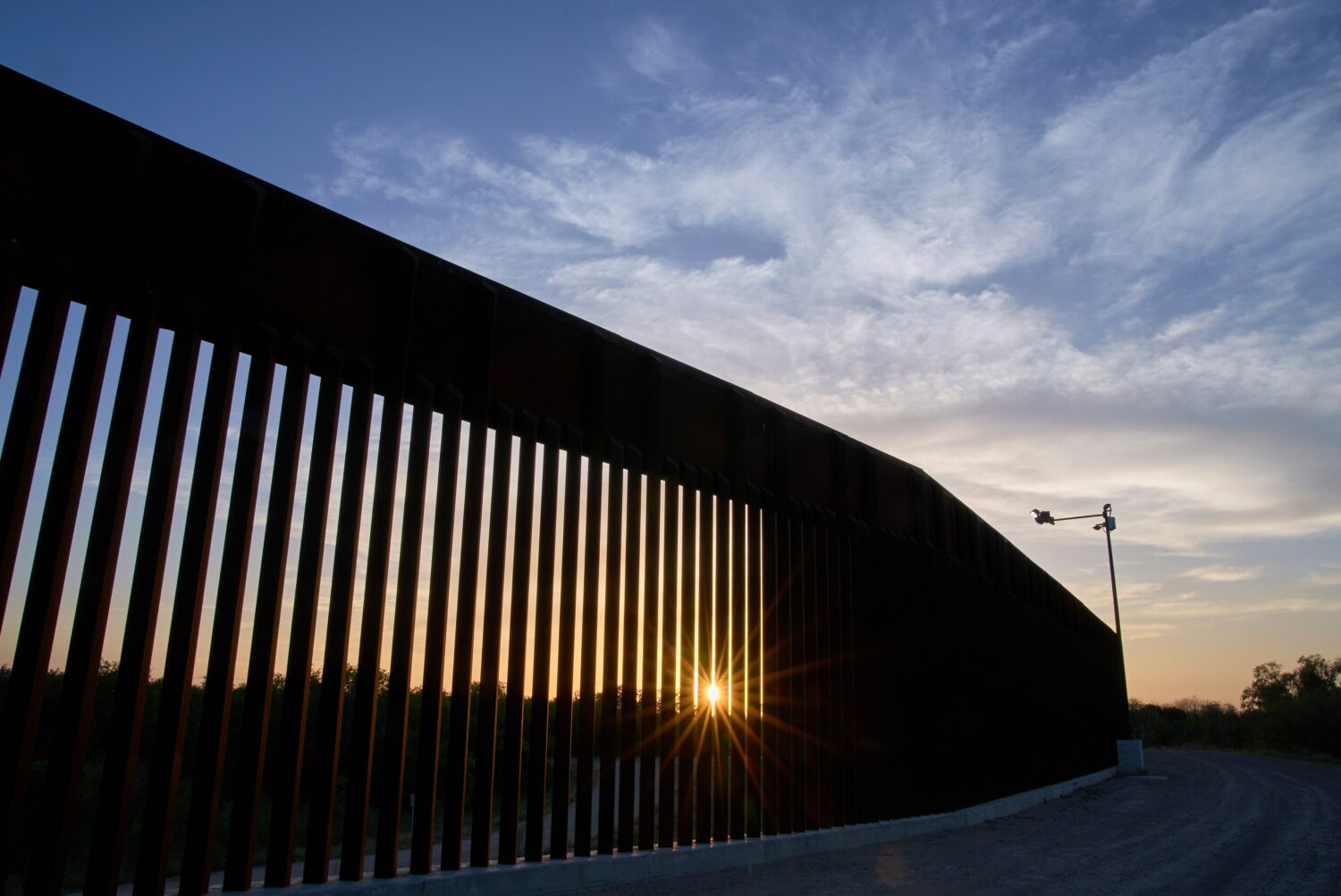 FILE - The sun sets over a section of the border wall, June 18, 2025, in Mission, Texas. (AP Photo/...