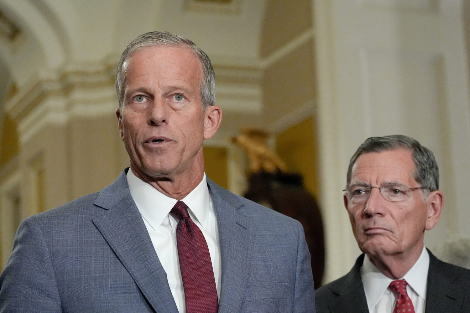Sen. Majority Leader John Thune, R-S.D., left, speaks as Sen. John Barrasso, R-Wyo., listens during...