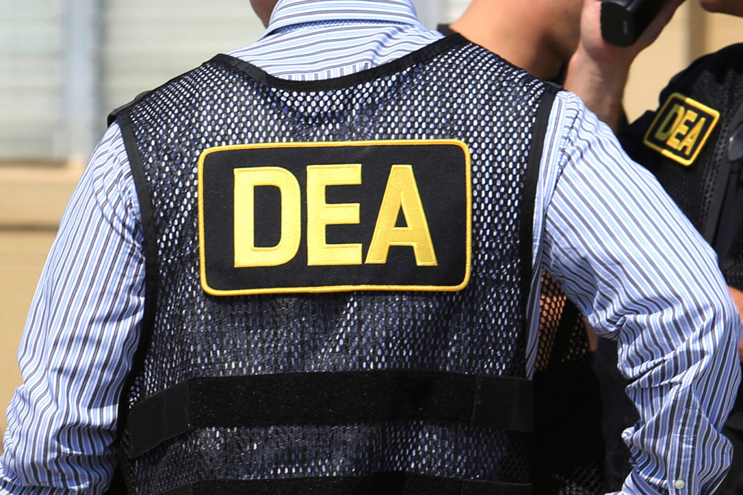 FILE - Lettering marks Drug Enforcement Administration agent's uniforms in Florida, June 13, 2016. ...