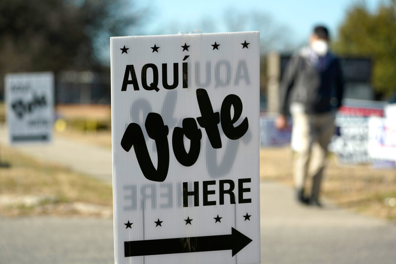FILE - A man passes an early voting poll site, Feb. 14, 2022, in San Antonio. (AP Photo/Eric Gay, F...