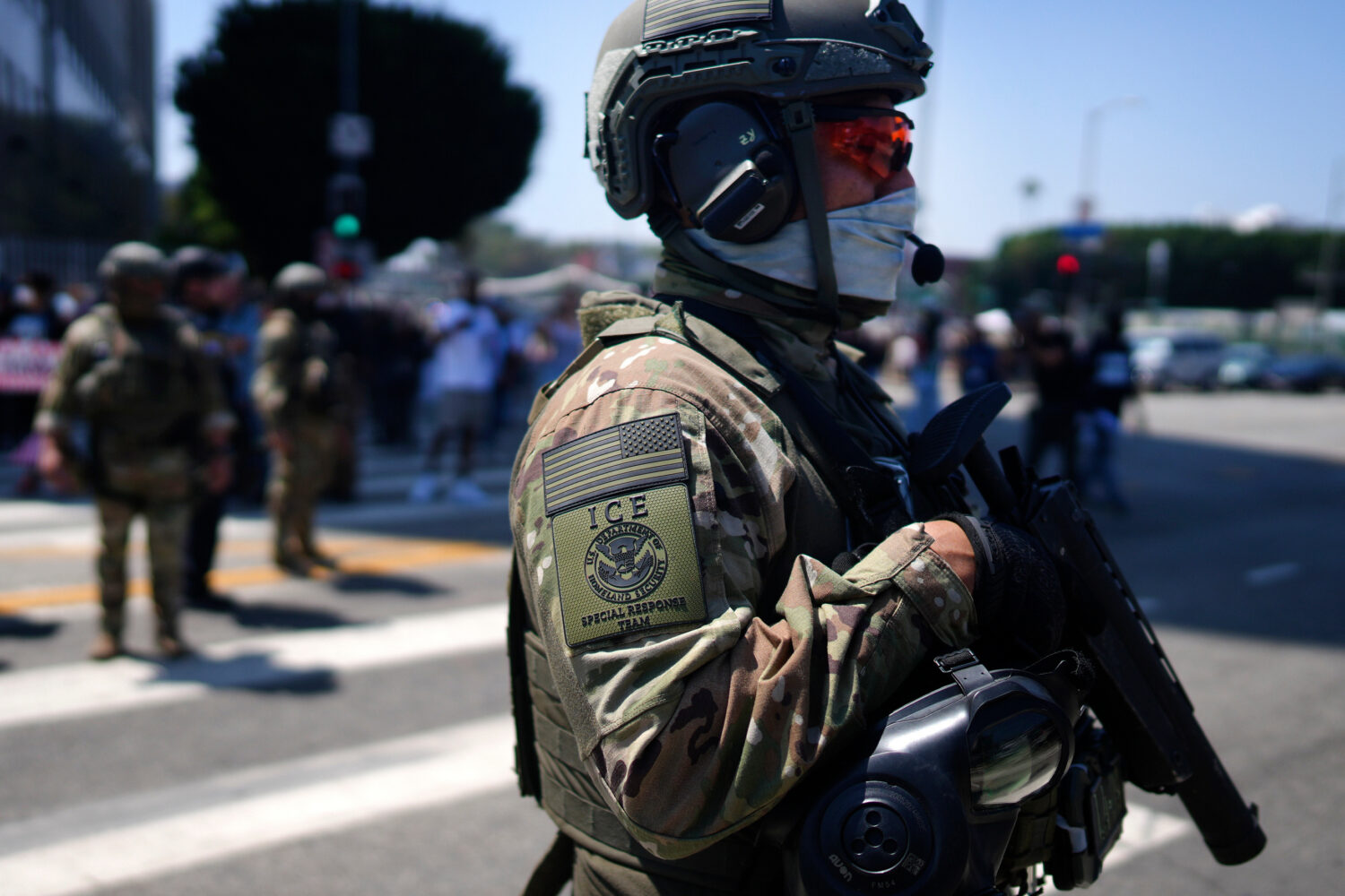 FILE - An ICE Special Response Team member stands guard outside the Metropolitan Detention Center, ...