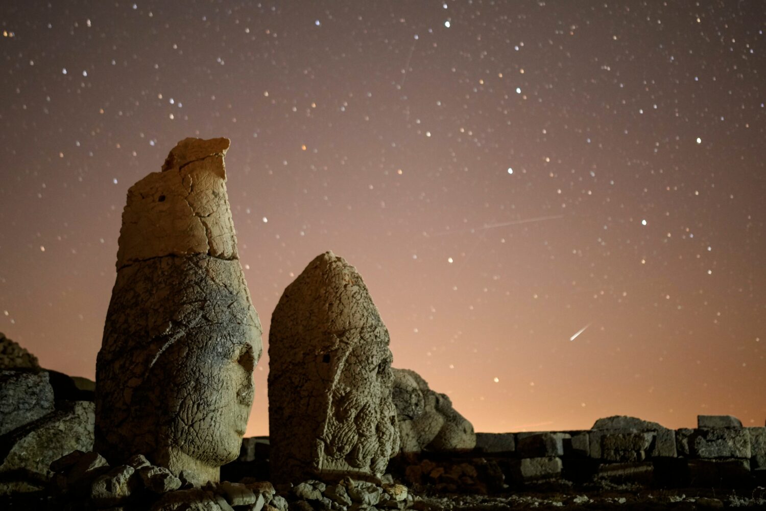 FILE - Ancient statues are seen during the Perseid meteor shower atop Mount Nemrut in southeastern ...