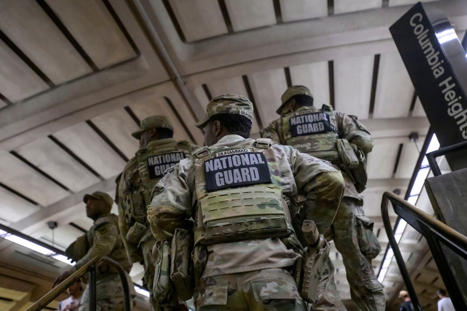 Members of the Arkansas National Guard continue their patrol after carrying an elderly woman in her...