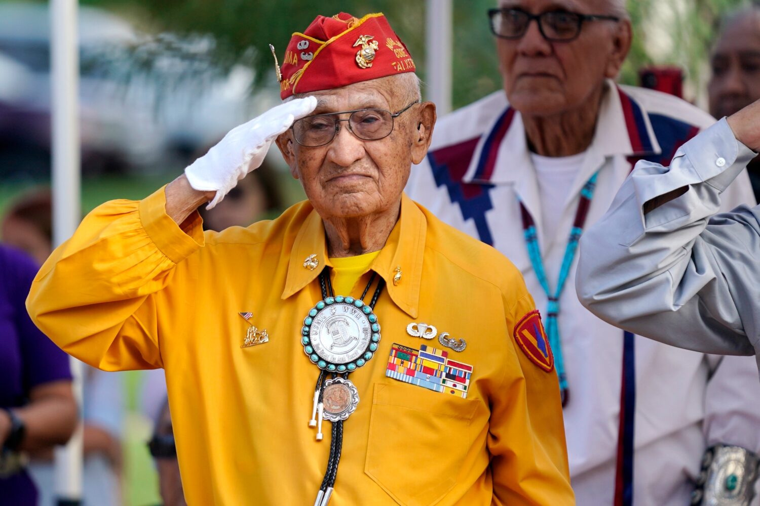 FILE - Navajo Code Talker Thomas Begay salutes during the national anthem at the Arizona State Nava...