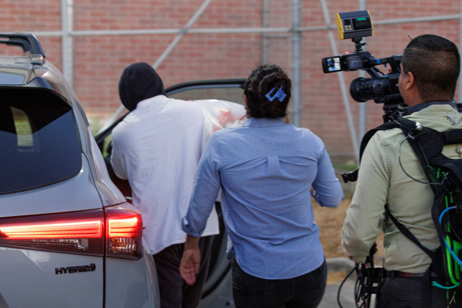Immigration and Customs Enforcement officer Christian Castro gets into a car surrounded by news rep...