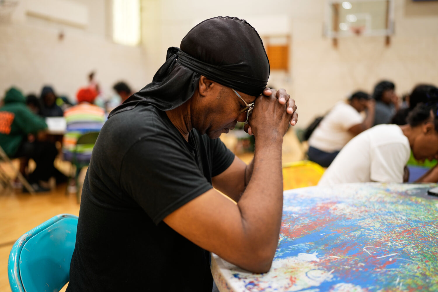 A person prays before receiving a free boxed lunch at City Life Center in Gary, Ind., Thursday, Aug...