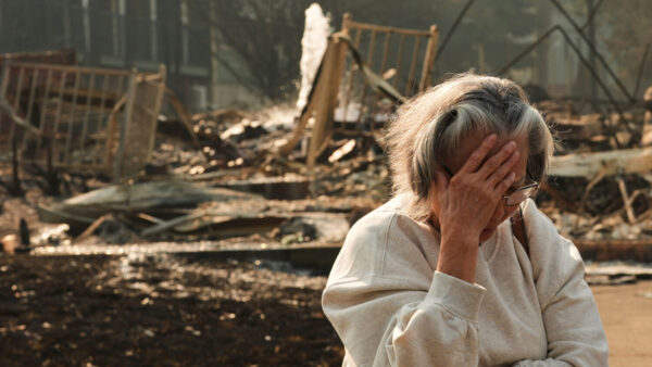 Miriam Sim, 76, reacts while talking about her neighborhood largely burning to the ground after a wildfire hit the northern part of Spokane, Washington, Monday, Aug. 3, 2026. (AP Photo/Lindsey Wasson)