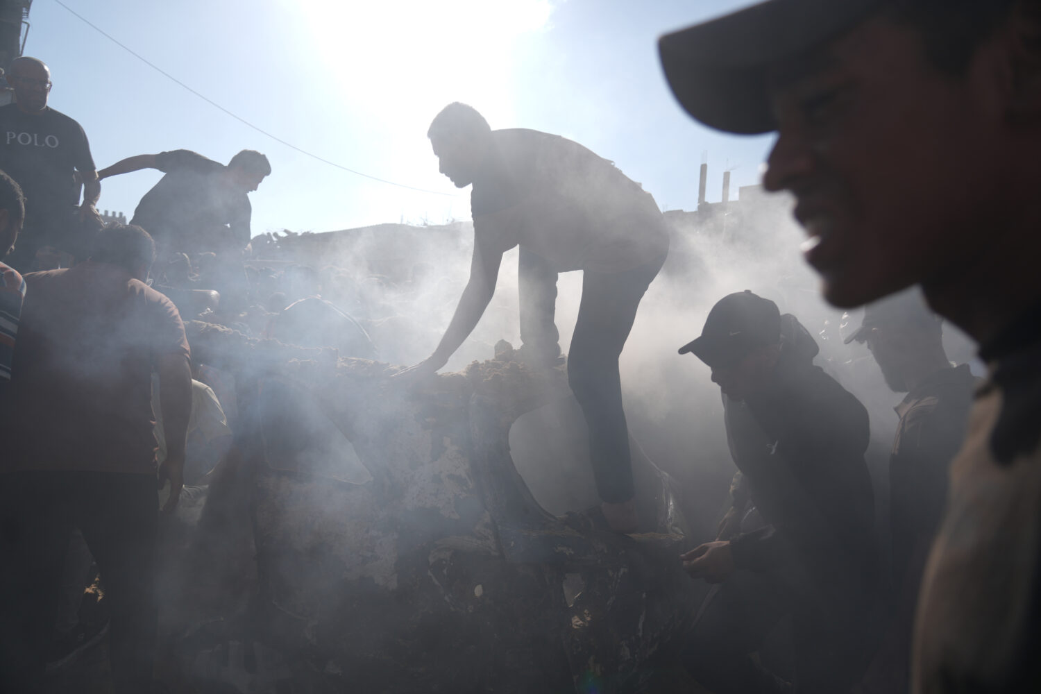People operate on a destroyed vehicle following an Israeli airstrike in Gaza city, Saturday, Sept. ...