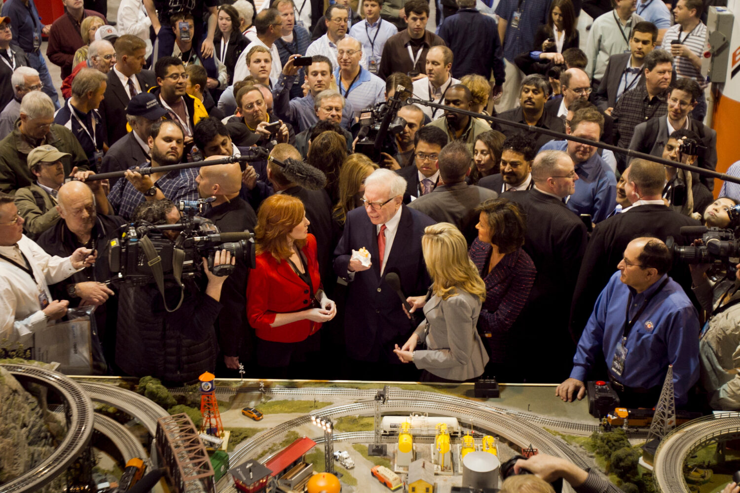 FILE - Berkshire Hathaway Chairman and CEO Warren Buffett, center, is surrounded by journalists and...