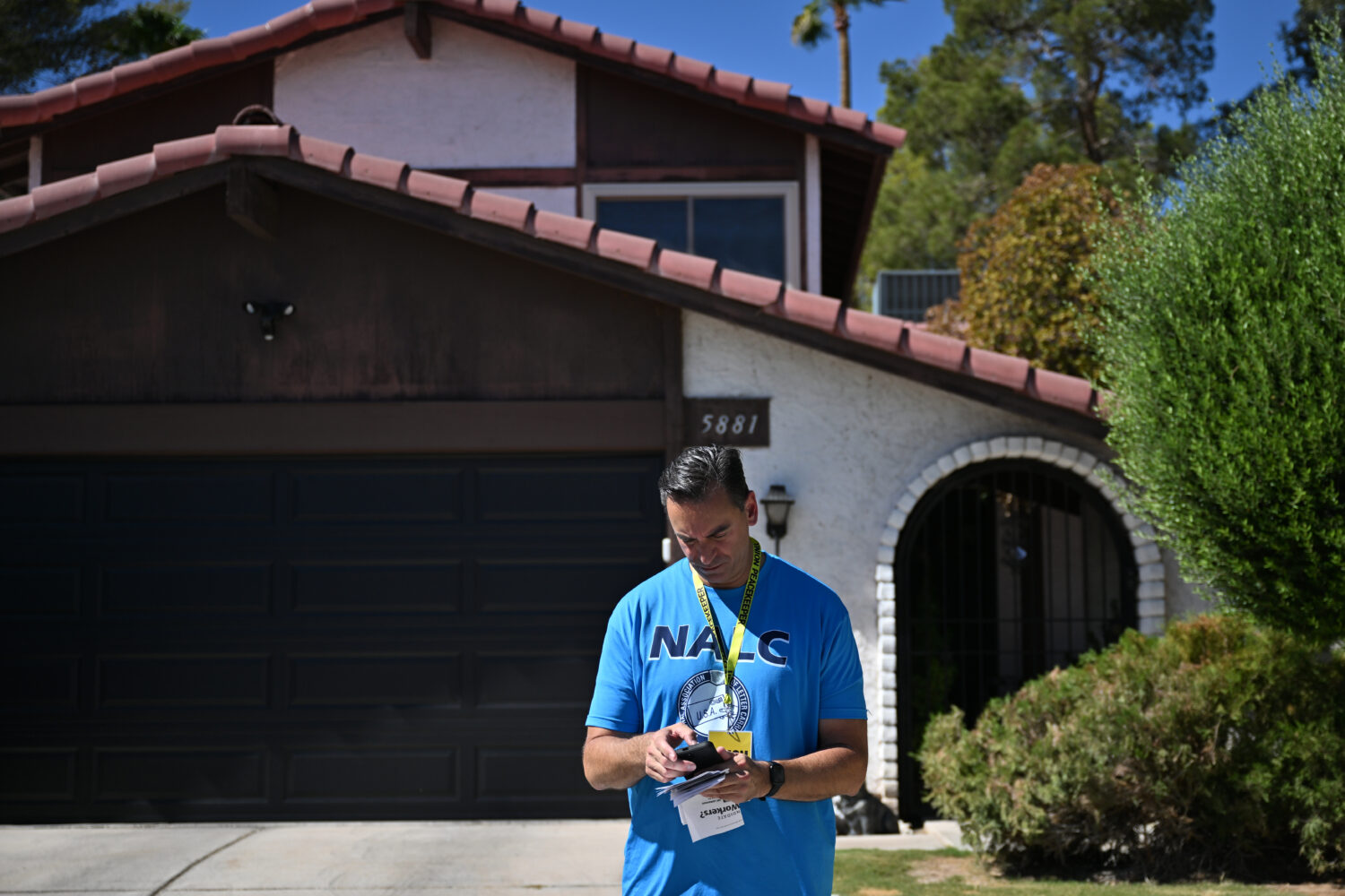 Paul Peterman of National Association of Letter Carriers checks his notes as he canvasses on Saturd...