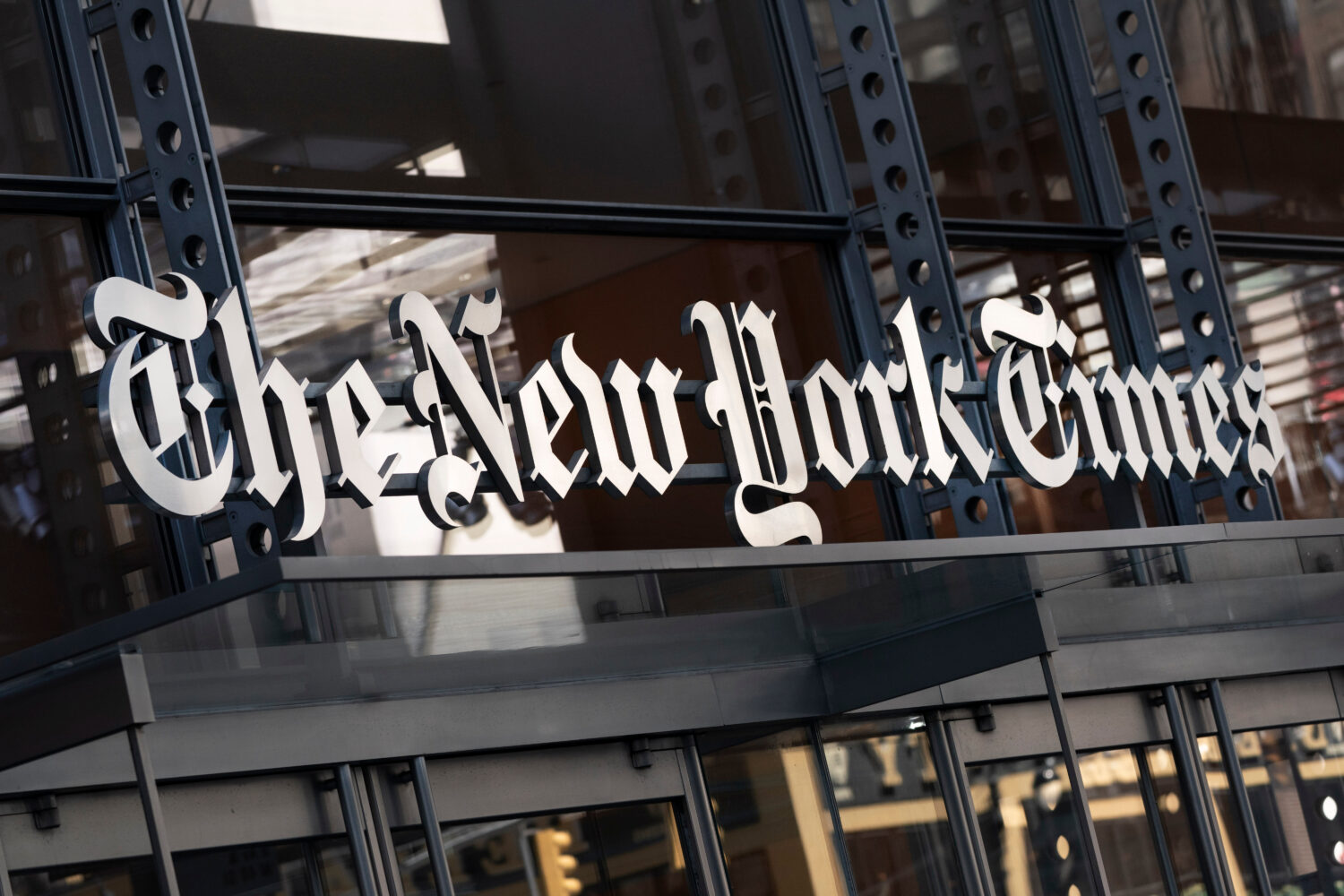 FILE - A sign for The New York Times hangs above the entrance to its building in New York, May 6, 2...