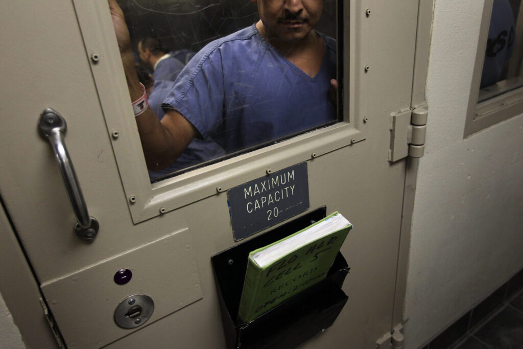 FILE - An immigrant stands in a holding cell at the U.S. Immigration and Customs Enforcement detention facility in Florence, Arizona. A private prison company has signed a deal with ICE to reopen a closed Marana prison as an immigration detention center. (Photo by John Moore/Getty Images)