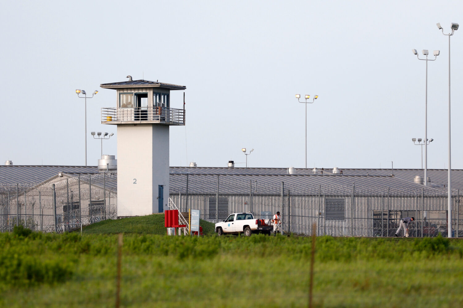FILE - An inmate works outdoors during a hot summer day outside a Texas prison unit in Huntsville, ...