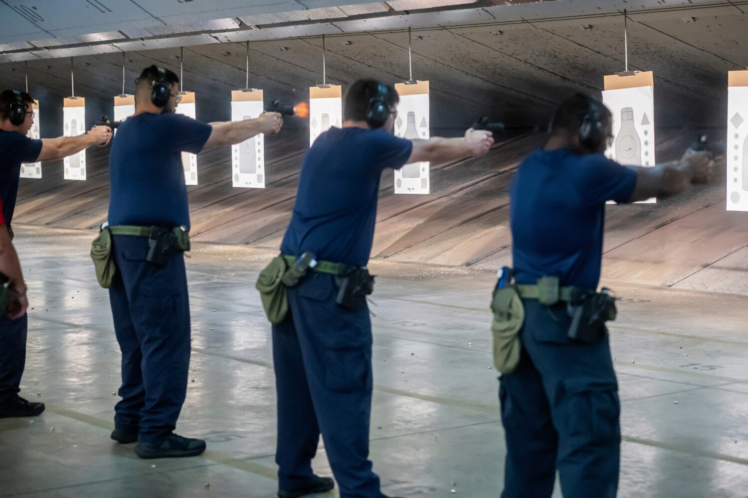 FILE - Immigration and Customs Enforcement (ICE) trainees practice shooting handguns at the indoor ...