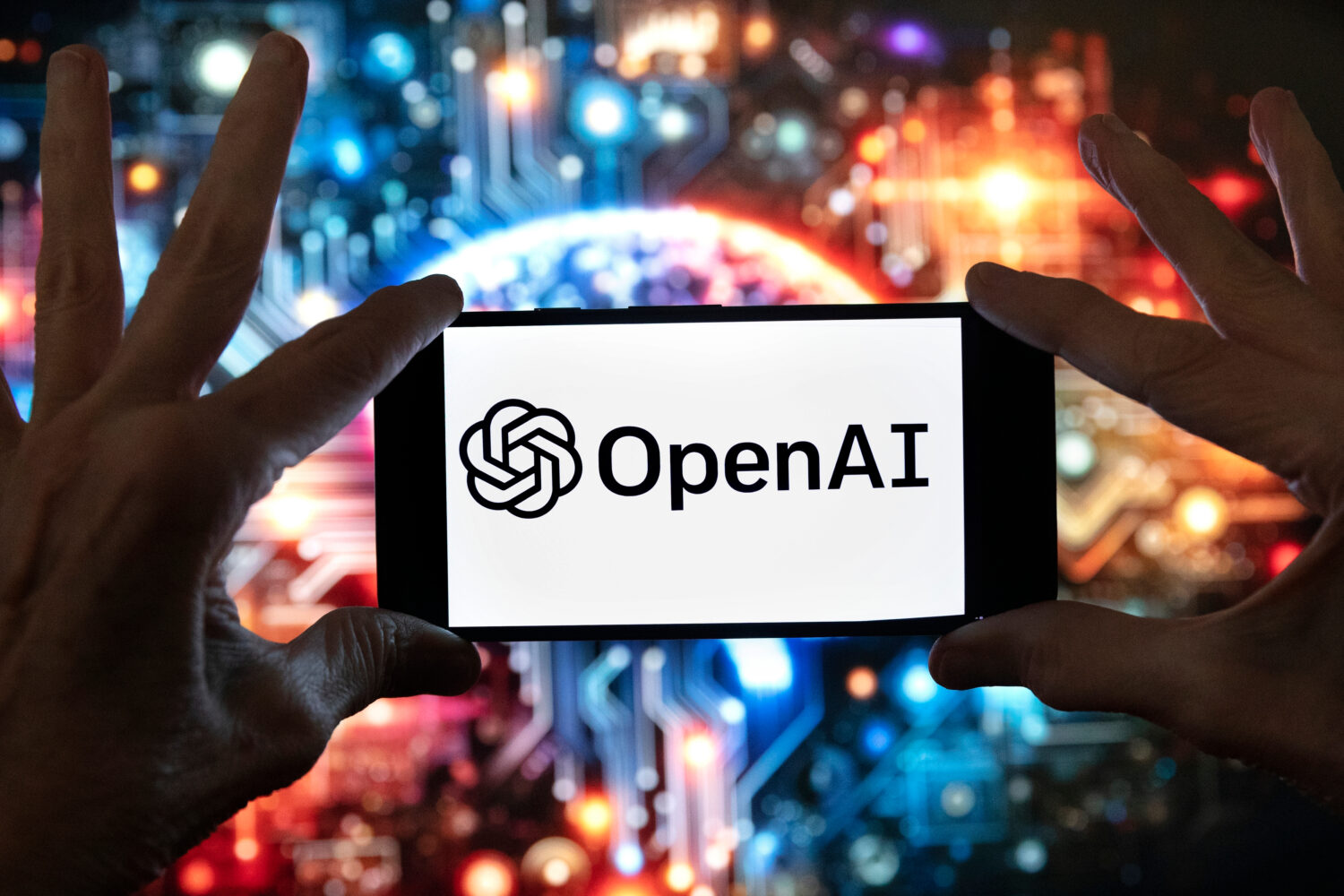 FILE - The OpenAI logo is displayed on a cell phone in front of an image generated by ChatGPT's Dal...