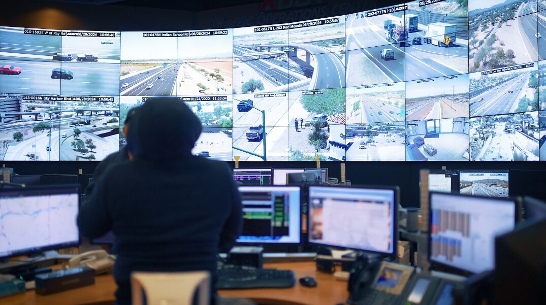 An ADOT operator monitors live freeway camera feeds inside the Traffic Operations Center in Phoenix...
