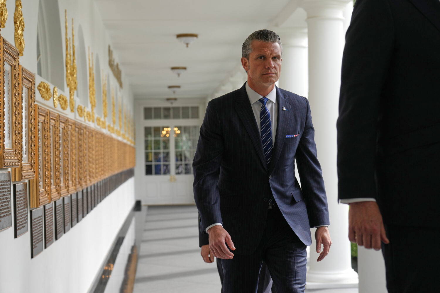 Defense Secretary Pete Hegseth walks along the Colonnade before President Donald Trump and China's ...
