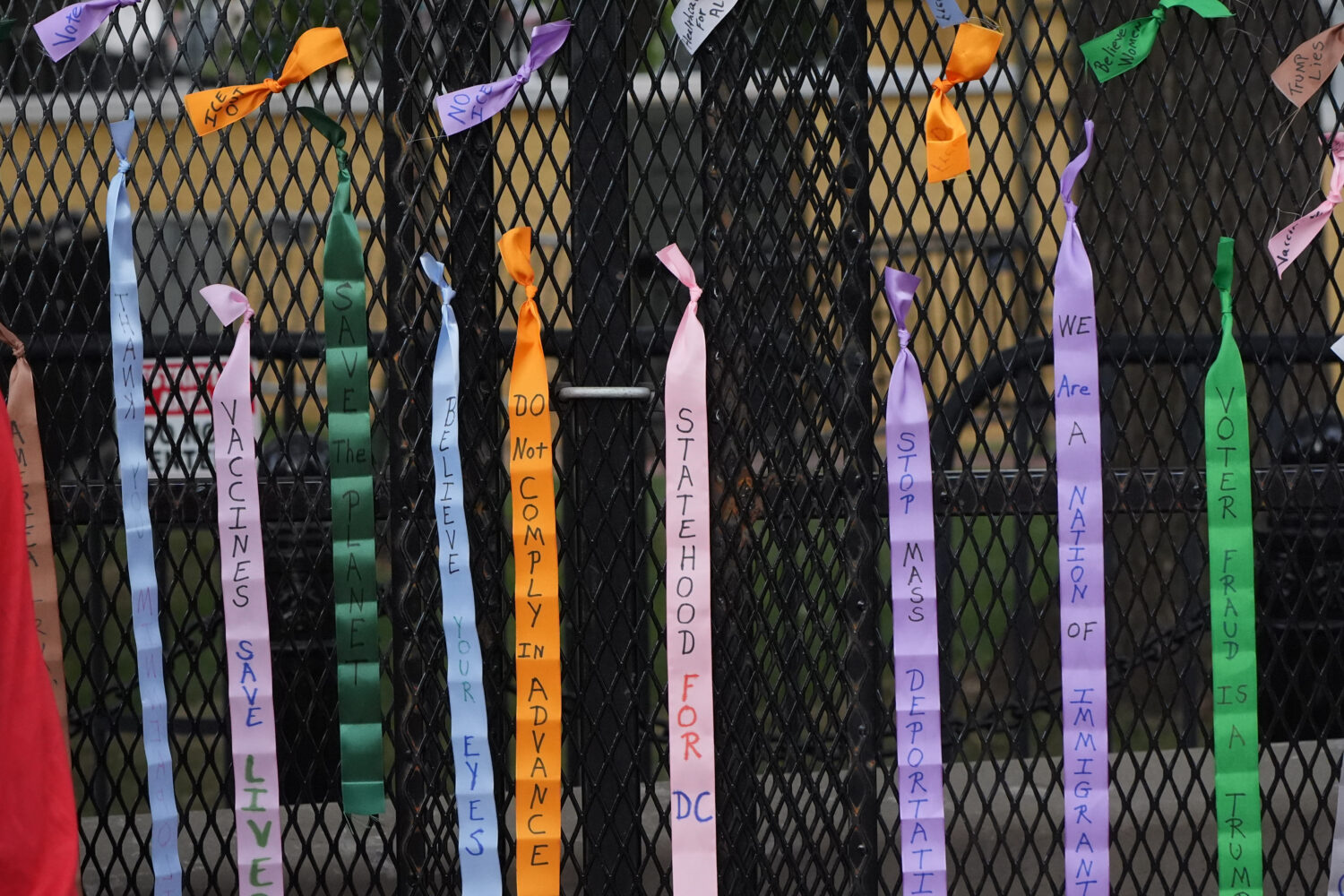Protest ribbons are tied to a fence at Lafayette Park, near the White House, Tuesday, Aug. 25, 2026...
