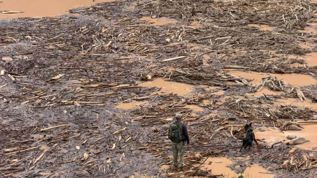 A search crew member with K-9 wade through the aftermath of flooding at the Grand Canyon. (Arizona DPS photo)