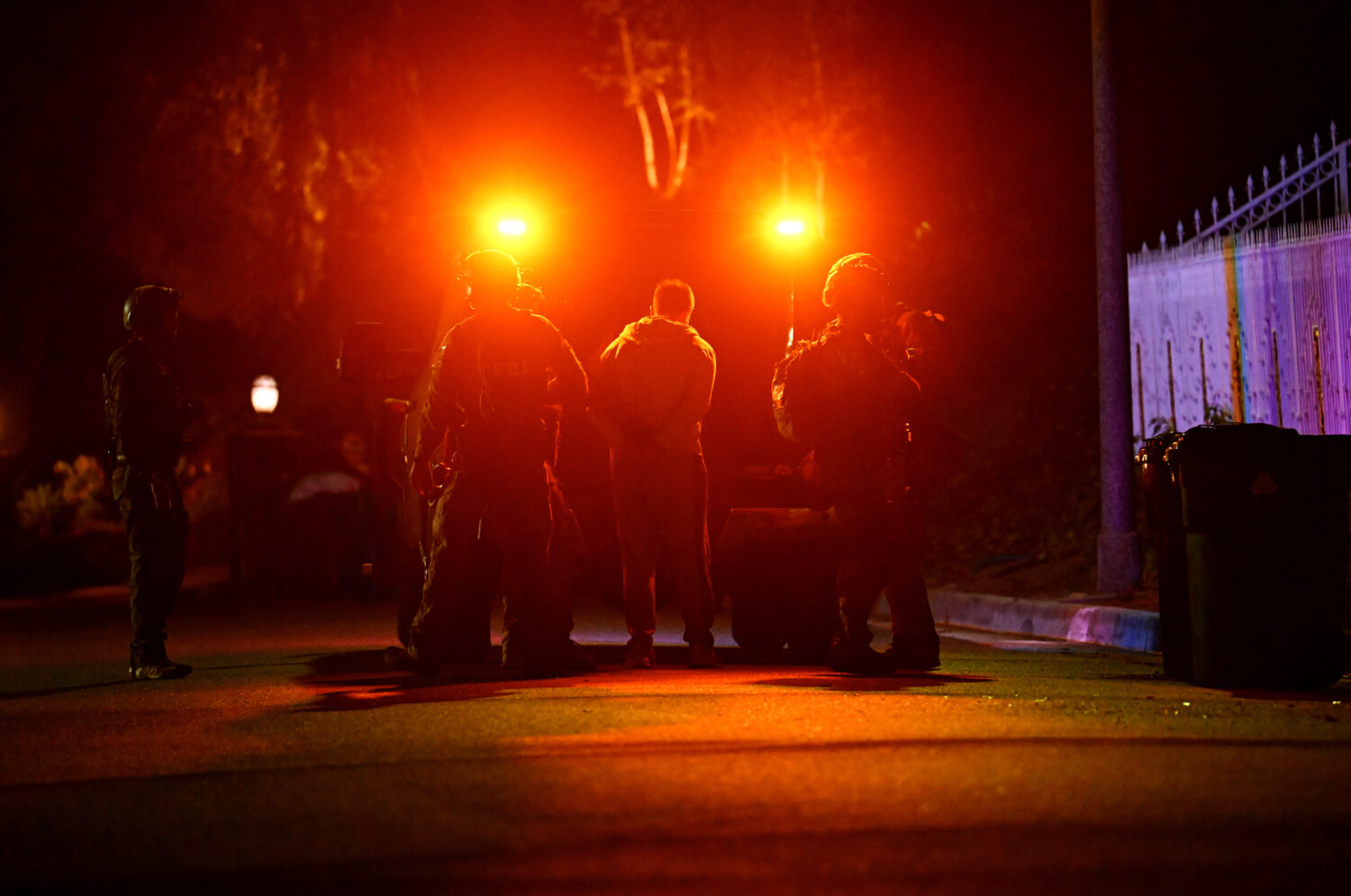 Federal agents arrest a suspect during a raid related to health care fraud in the early morning on ...