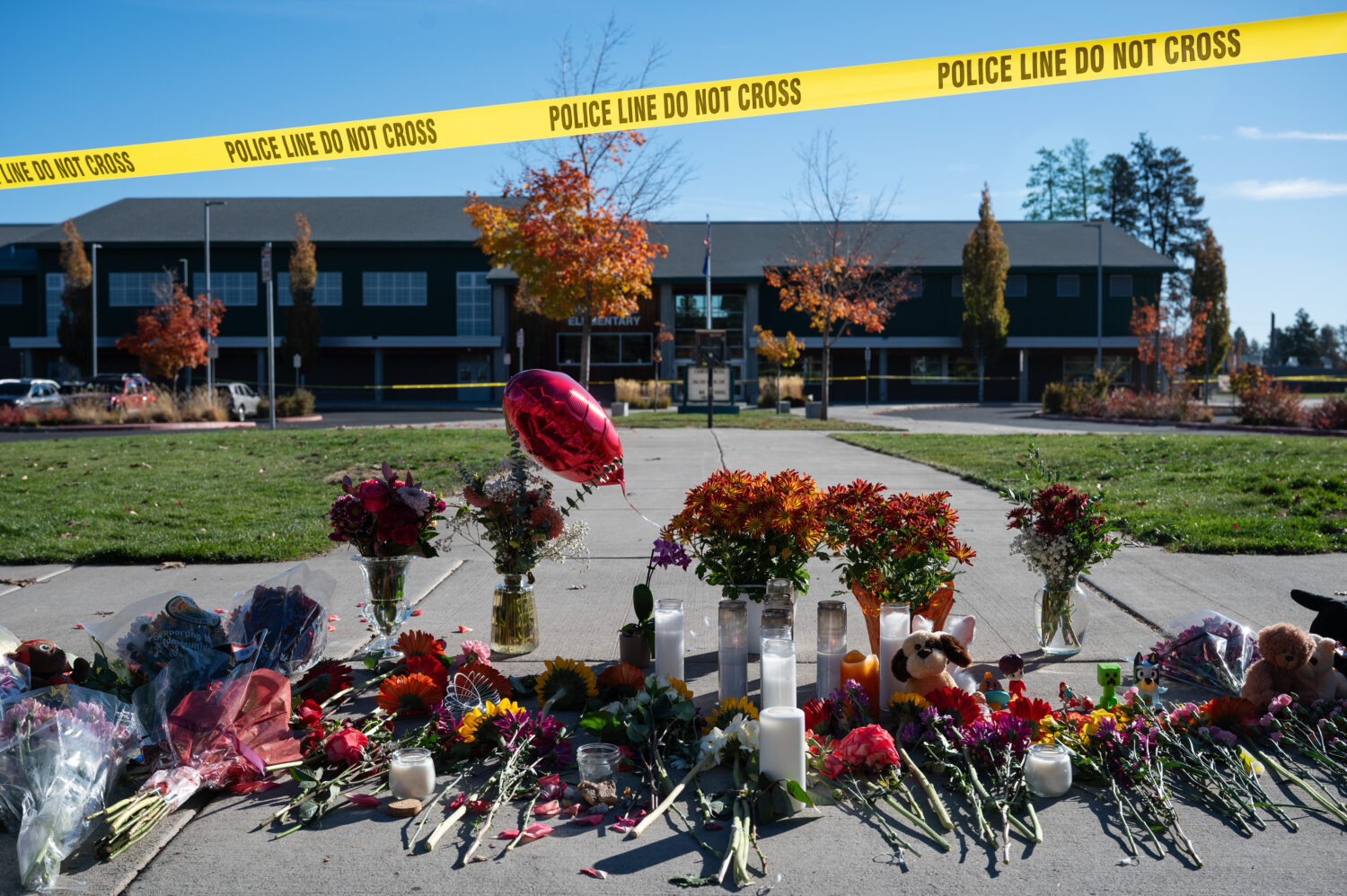 Flowers and candles are seen at a makeshift memorial outside Silver Rail Elementary in Bend, Ore., ...