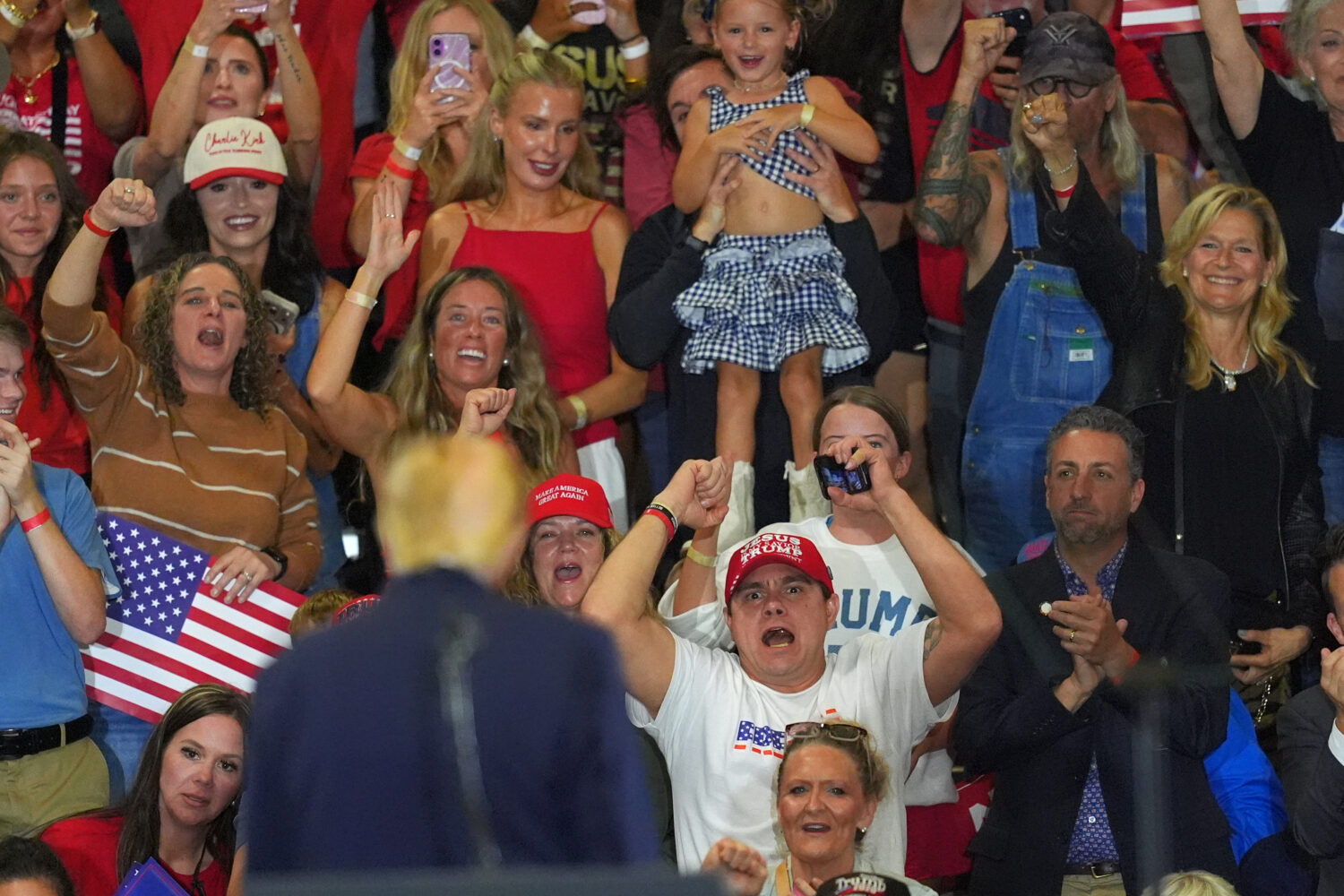 People react as President Donald Trump speaks at a campaign rally at the Choctaw Event Center, Thur...