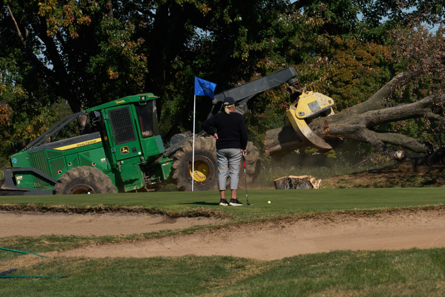 A golfer watches as trees are removed at East Potomac Park Golf Course, Monday, Oct. 26, 2026, in W...