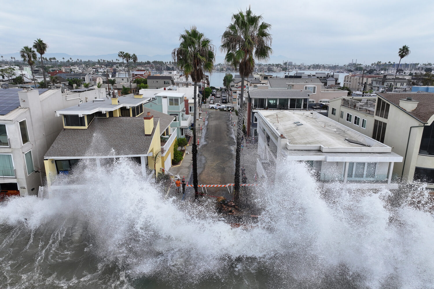 Waves hit a walkway in front of homes in Long Beach, Calif., Saturday, Oct. 10, 2026, as Tropical S...