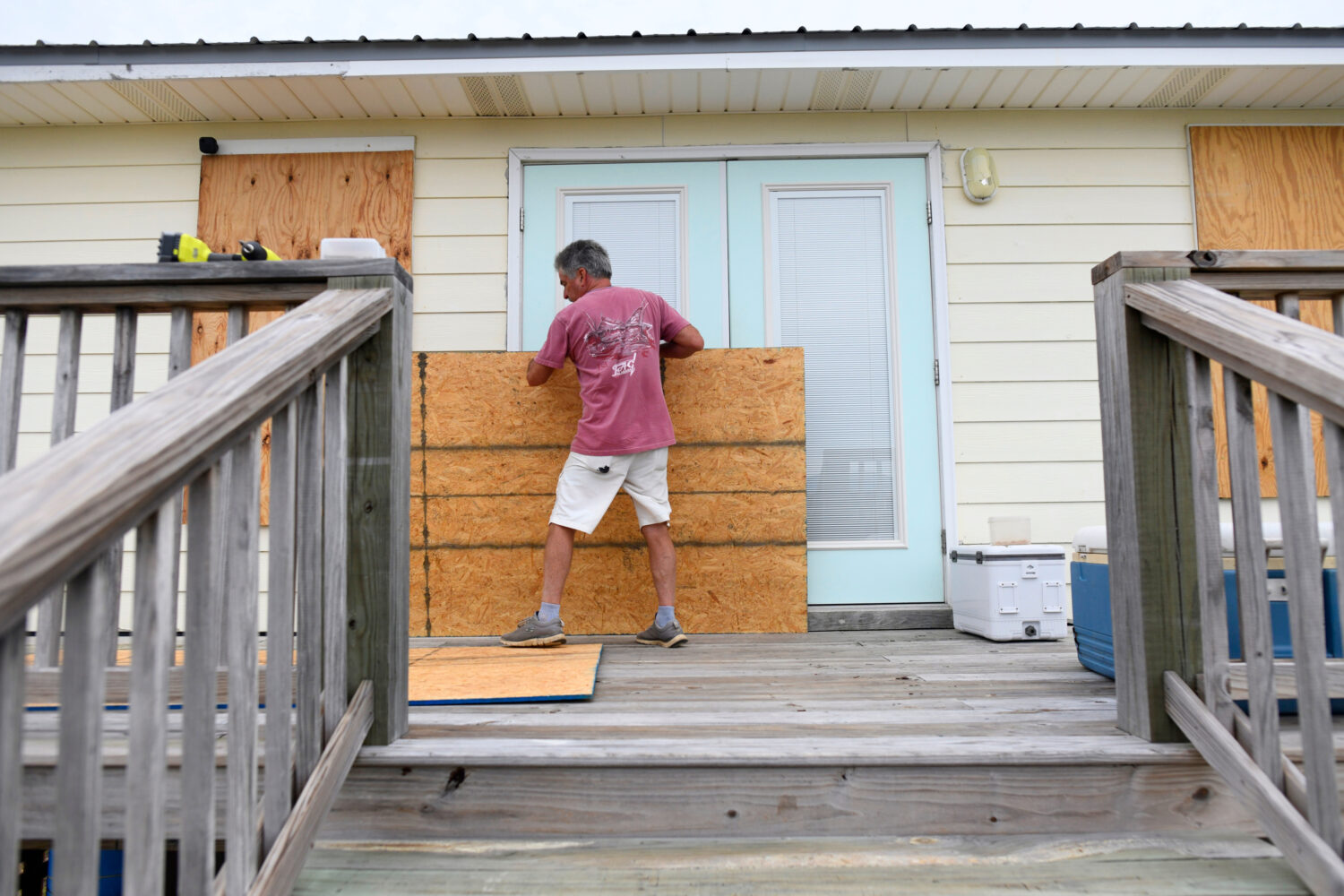 Larry Smith boards up his home with plywood ahead of Hurricane Isaias' expected landfall along the ...