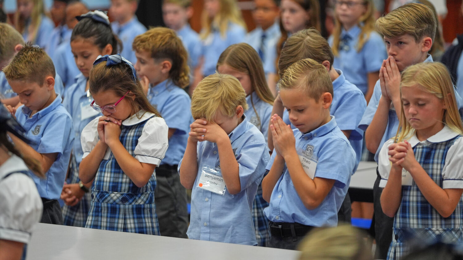 Children at Covenant Christian Academy pray during chapel at the private school in Colleyville, Tex...