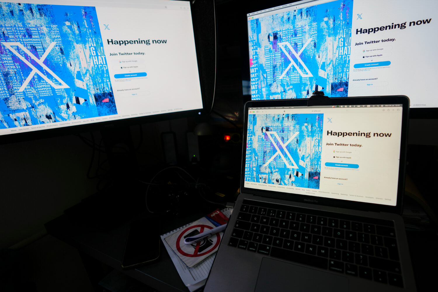 FILE - Computer monitors and a laptop display the X, formerly known as Twitter, sign-in page, July ...