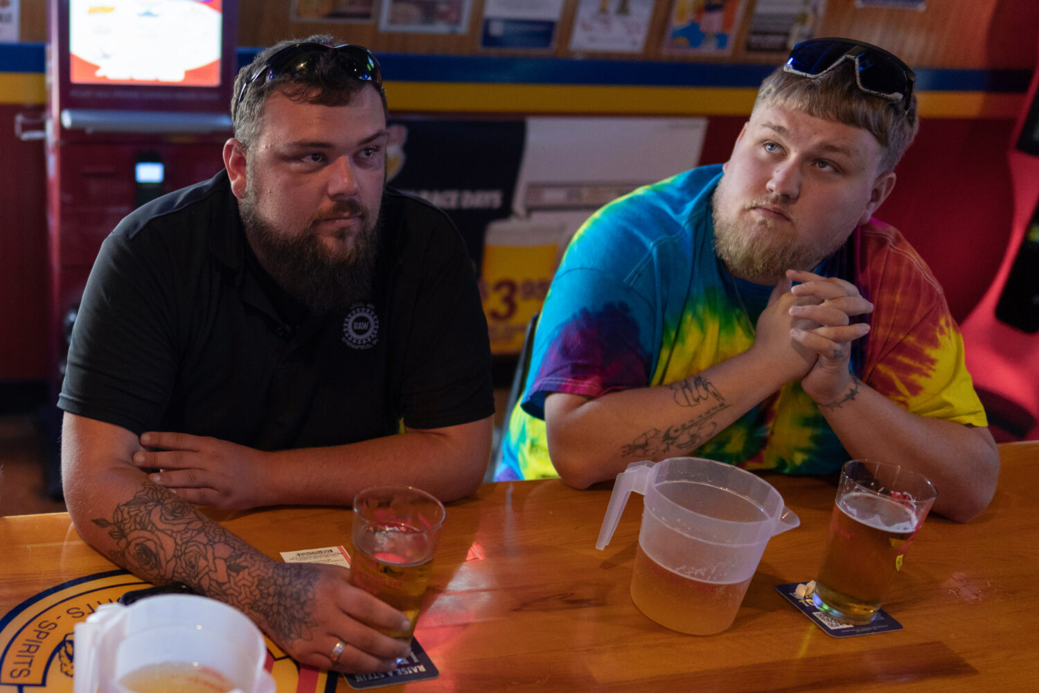 UAW Local 402 members Chaz Graham, left, and Kyle Bos, right, share a beer at Fricker's restaurant ...