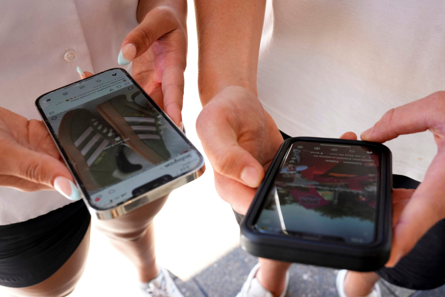 FILE - Young people use their phones to view social media in Sydney on Nov. 8, 2024. (AP Photo/Rick...