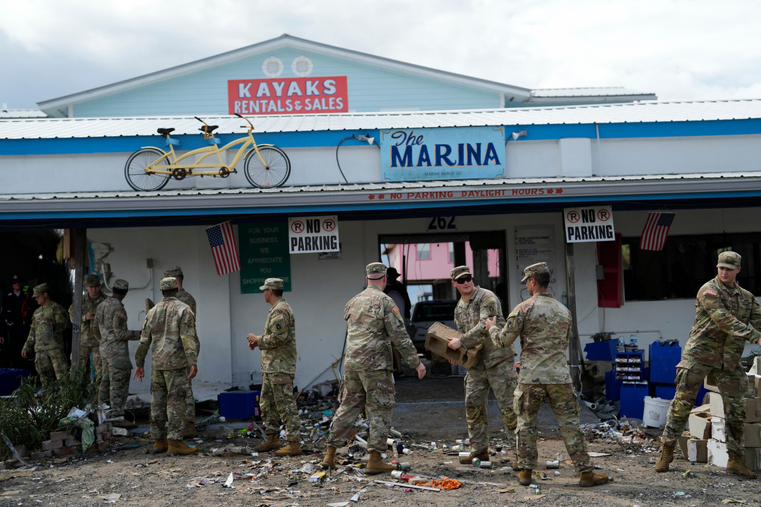 FILE - Members of the National Guard assist storm-damaged business The Marina with moving and pilin...