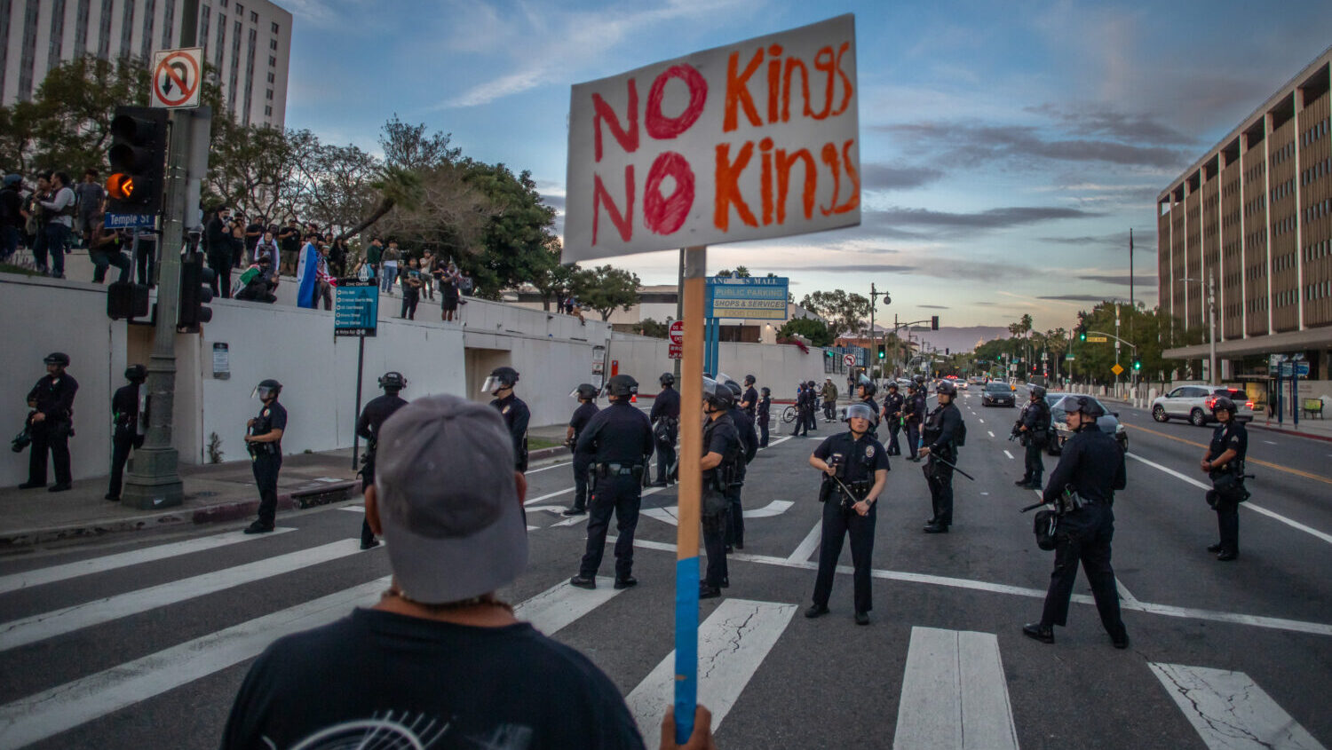 A man holds a sign near the Metropolitan Detention Center to protest immigration enforcement and Fe...
