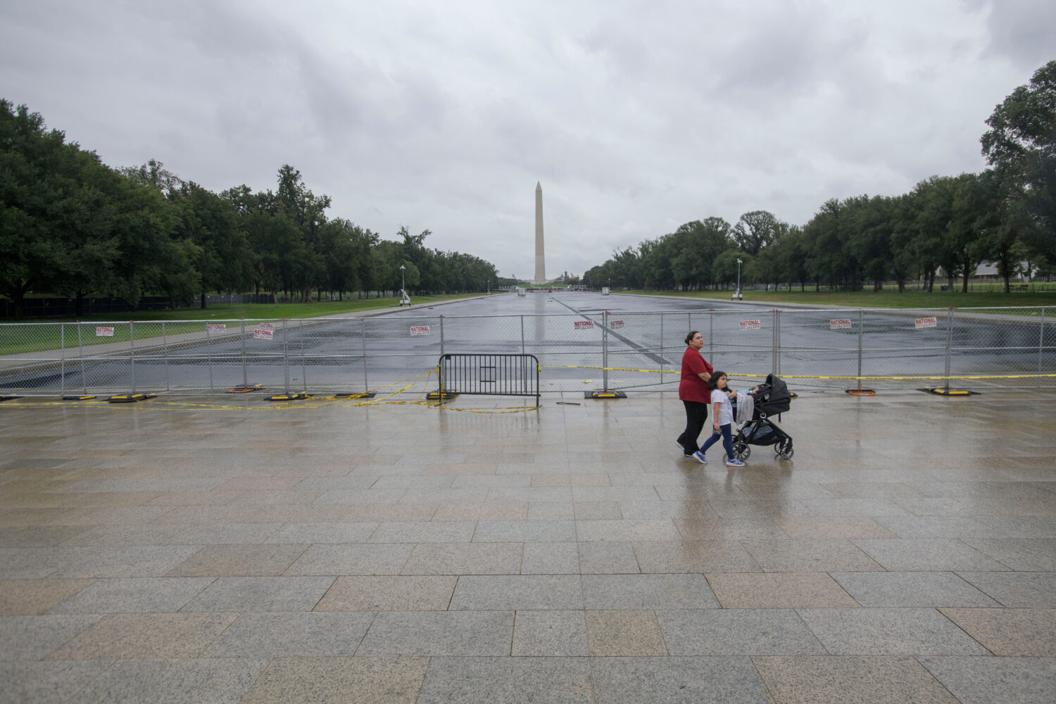 People pass by an empty Reflecting Pool at the Lincoln Memorial in Washington, Monday, Sept. 21, 20...