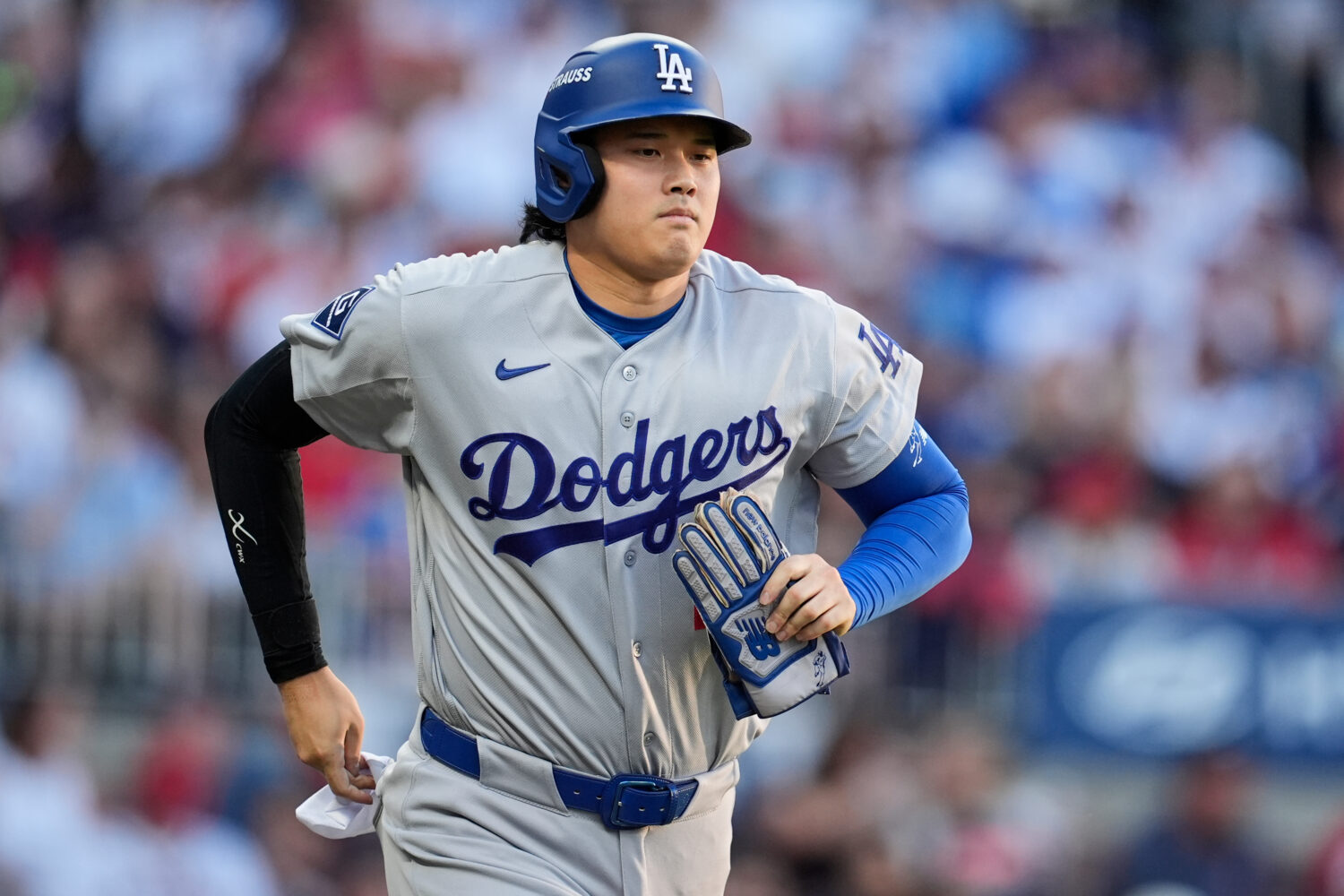 Los Angeles Dodgers two-way player Shohei Ohtani advances to first base on a walk during the second...
