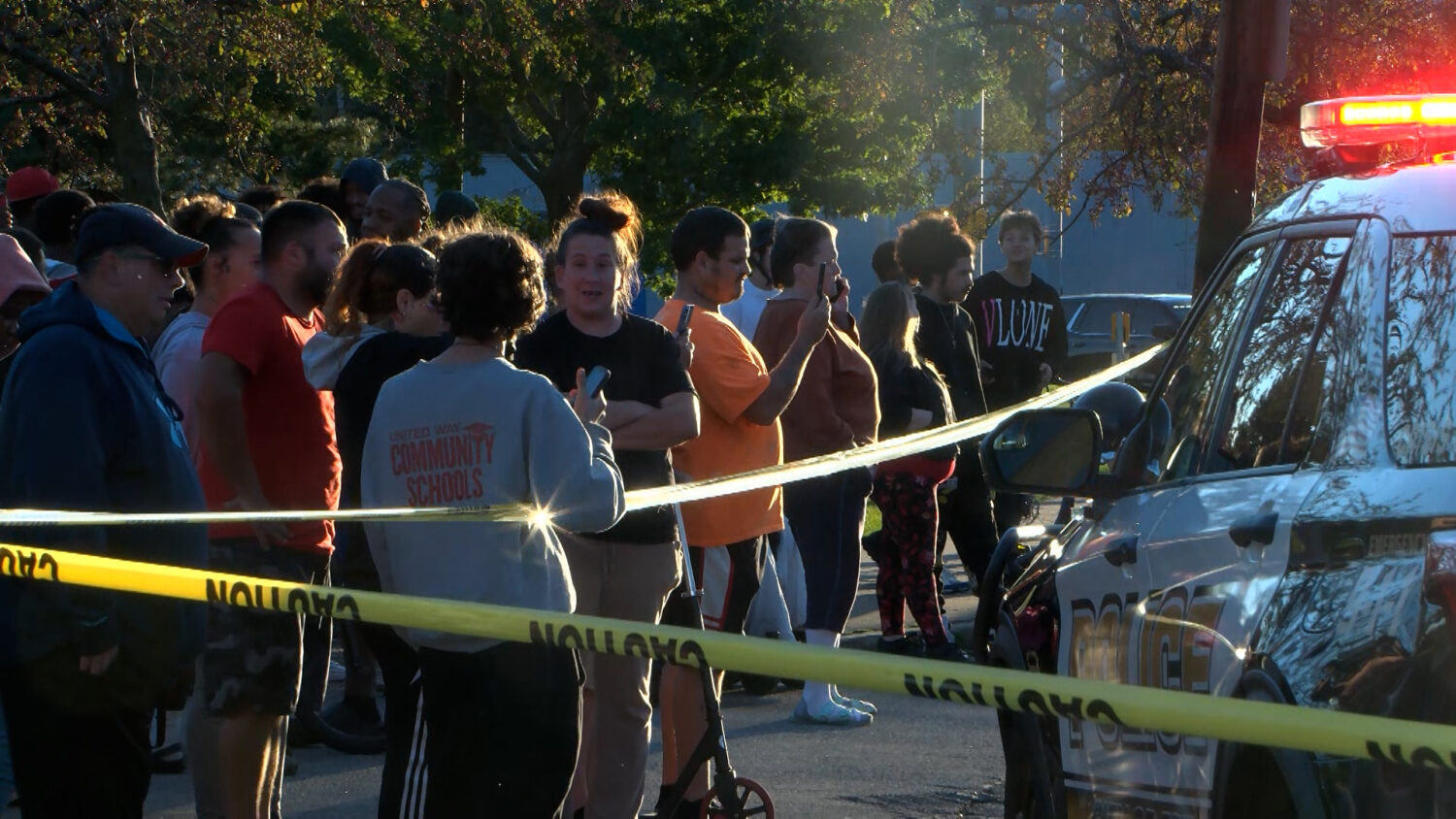 In this image from video provided by WJET, bystanders gather outside the scene of a shooting in Eri...