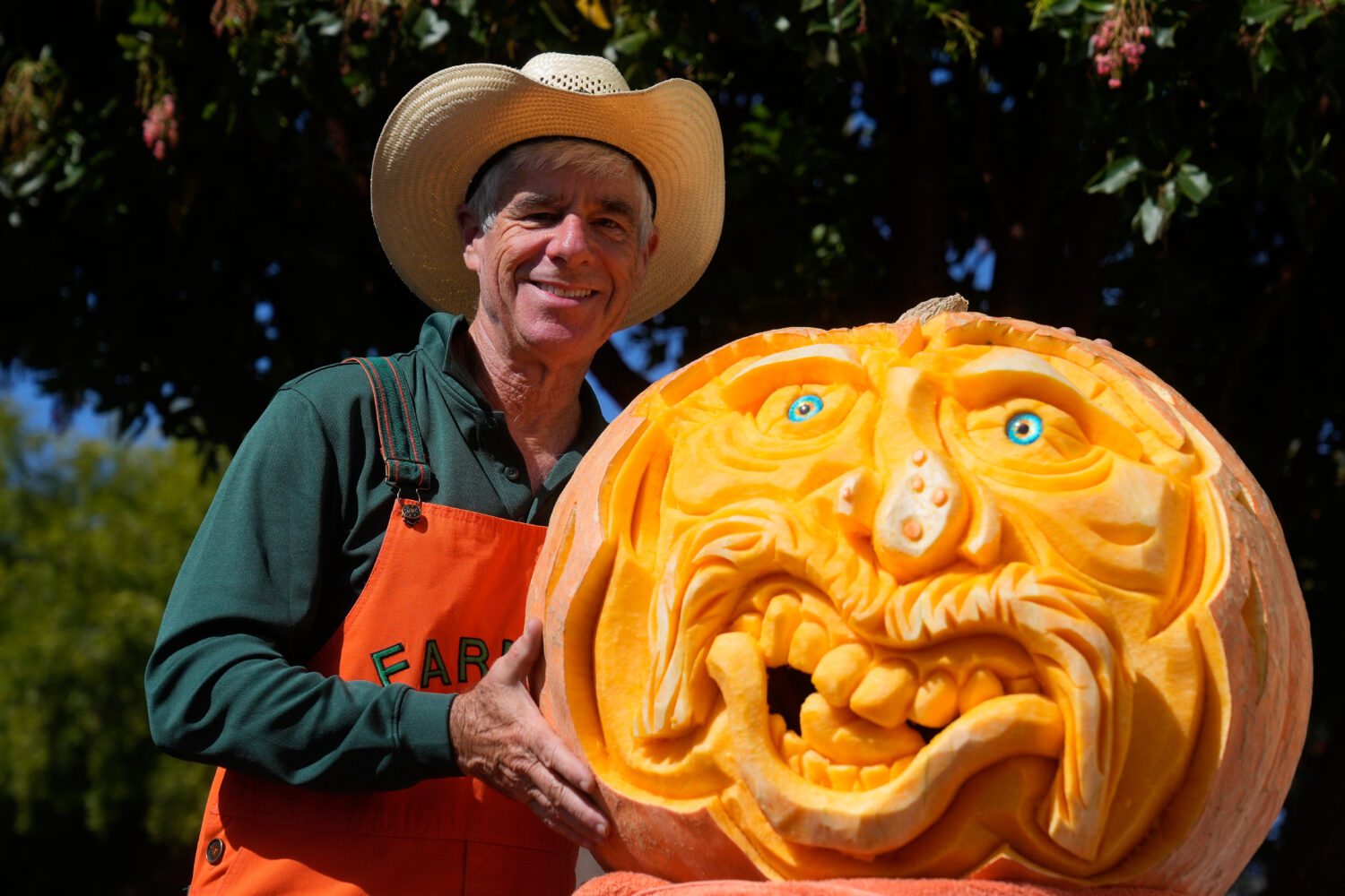 Farmer Mike Valladao poses next to a pumpkin he carved at the Safeway World Championship Pumpkin We...