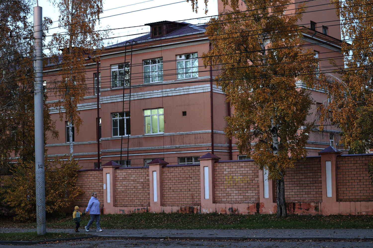 A woman with her child walks past the building of the Irkutsk Anti-Plague Research Institute of Sib...
