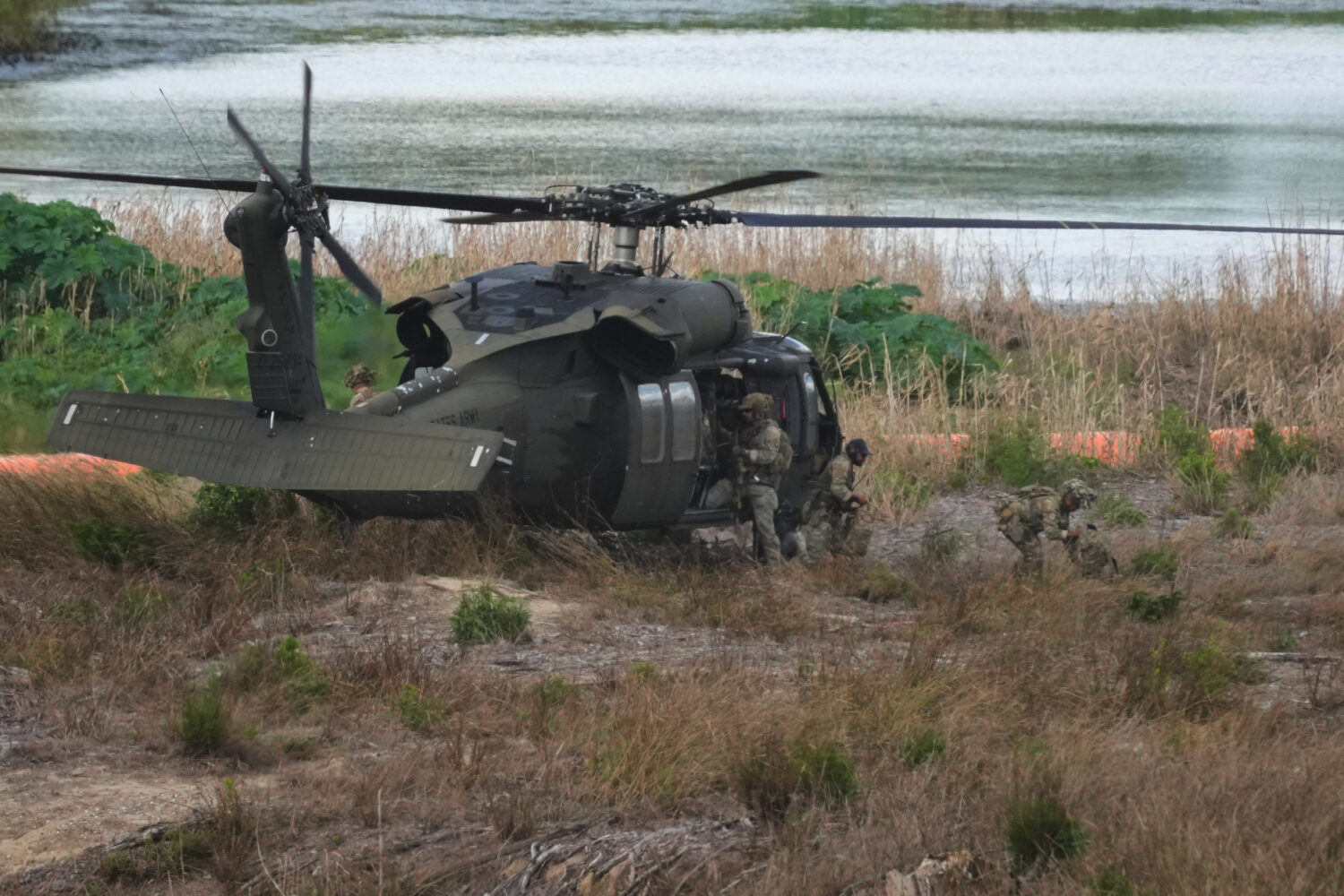 Troops disembark from a U.S. Army helicopter on an island along the Rio Grande in Roma, Texas, Thur...