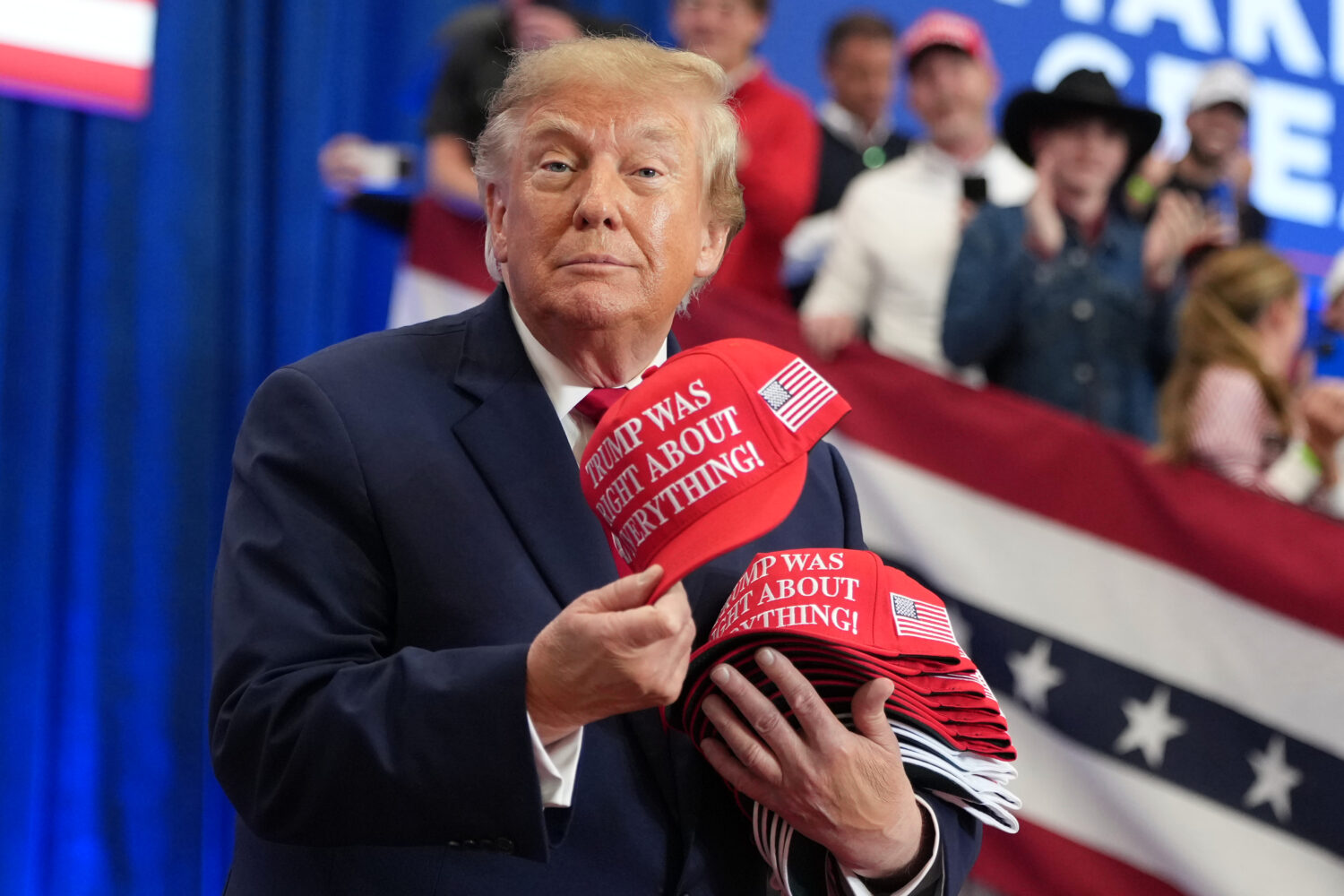 President Donald Trump tosses hats into the crowd as he arrives at a campaign rally at the Lubbock ...