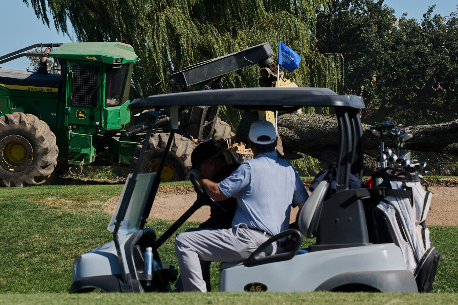 People drive a golf cart past ongoing tree removal at East Potomac Park Golf Course, Monday, Oct. 2...