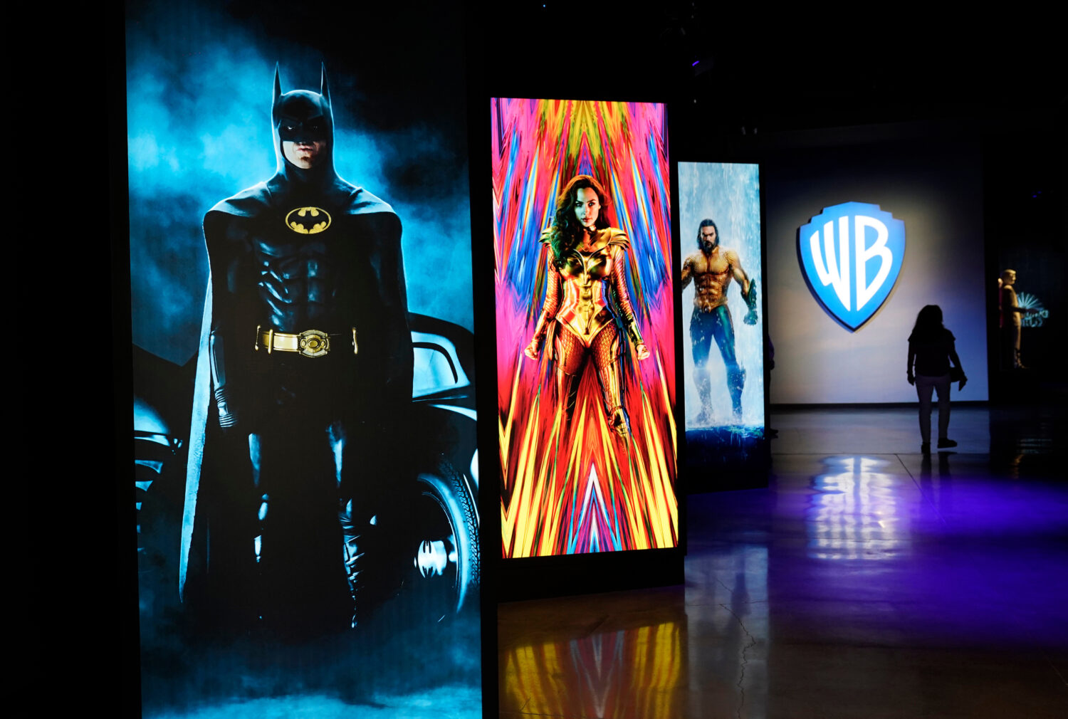 FILE - A visitor walks past portraits of DC Comics superheroes as she enters the "Action and Magic ...