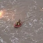 Rescuers make their way back to shore with the man in the raft. (Screenshot)