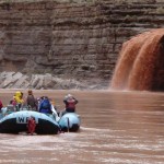 Rafters watch a flashflood pouring from a sidecanyon. (Photo: Steven Law)